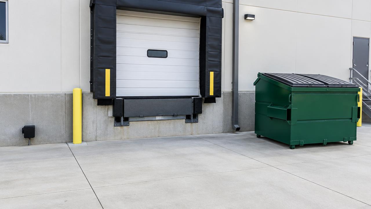 Maintained loading dock with sealed door, lidded dumpster and an exterior monitoring station